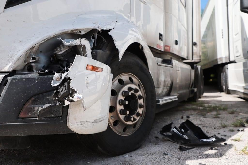 A semi-truck with front-end damage, indicated involvement in collision or accident