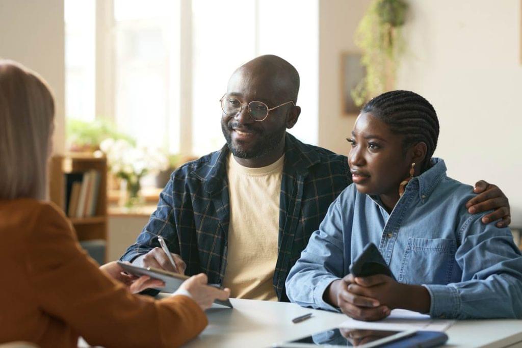 Couple meeting with an attorney, discussing legal options and taking notes during a consultation.